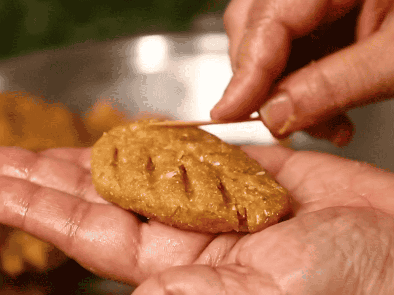 Shaping Thekua dough into small round and oval pieces