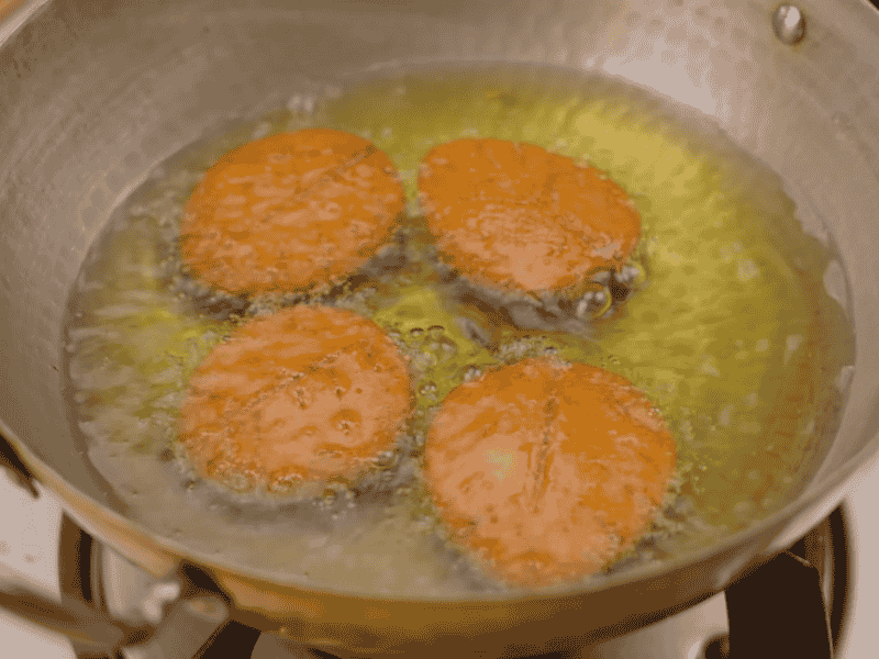 Deep frying Thekua in ghee until golden brown