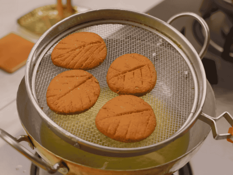 Deep frying Thekua in ghee until golden brown