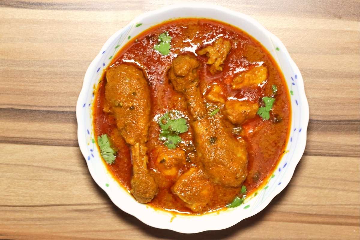 Aloo Diye Murgir Jhol served in a bowl, garnished with coriander leaves.